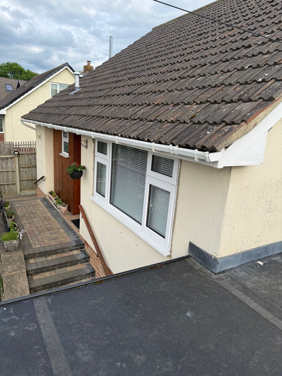 The front entrance of the bungalow before work, cream render around a timber door and brick steps