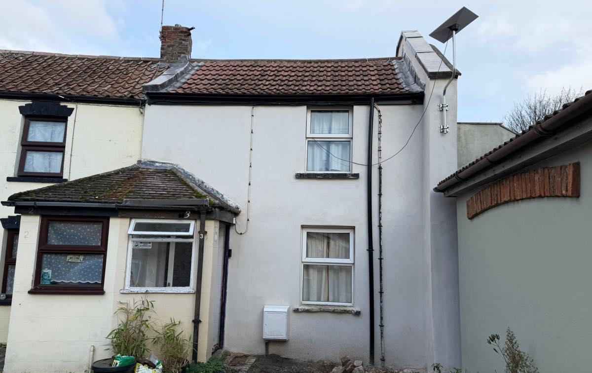 An end-terrace cottage finished in smooth white render, front and side elevations complete