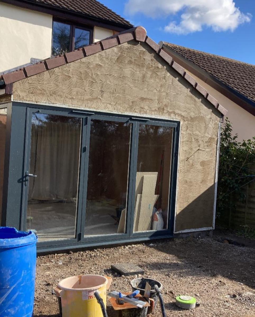 A fresh scratch coat on an extension gable with anthracite bi-fold doors below