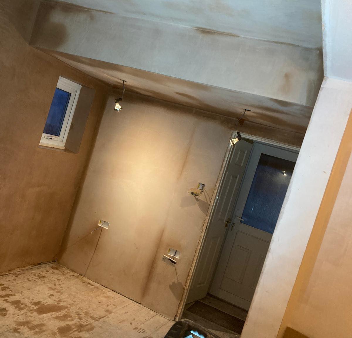 A loft room with sloping ceiling, walls and window reveal freshly skimmed