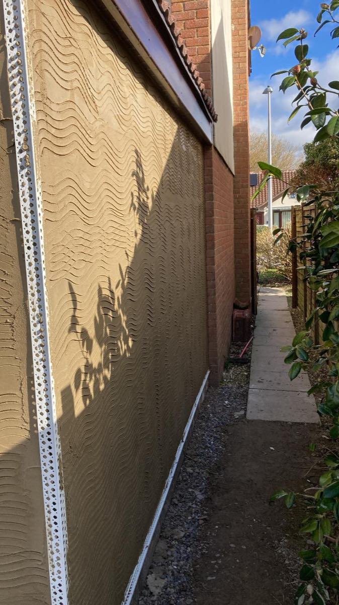 A sand and cement scratch coat combed up along a side passage with beads set at both edges